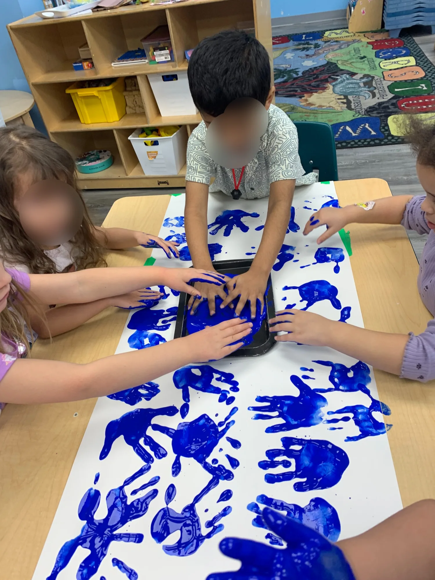 Village Scholars Preschool photo: handprints and shared blue paint