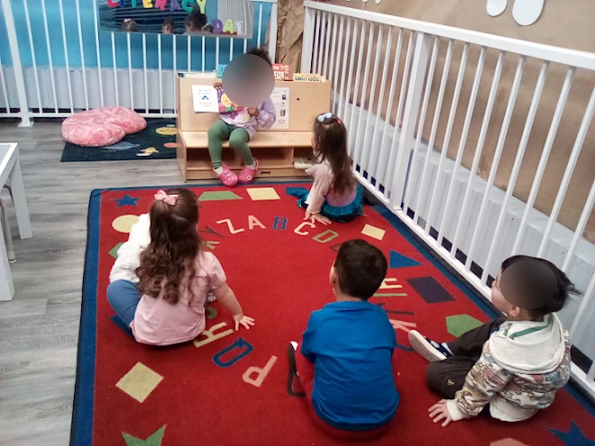Child reading a book to classmates during a typical day at Village Scholars Preschool